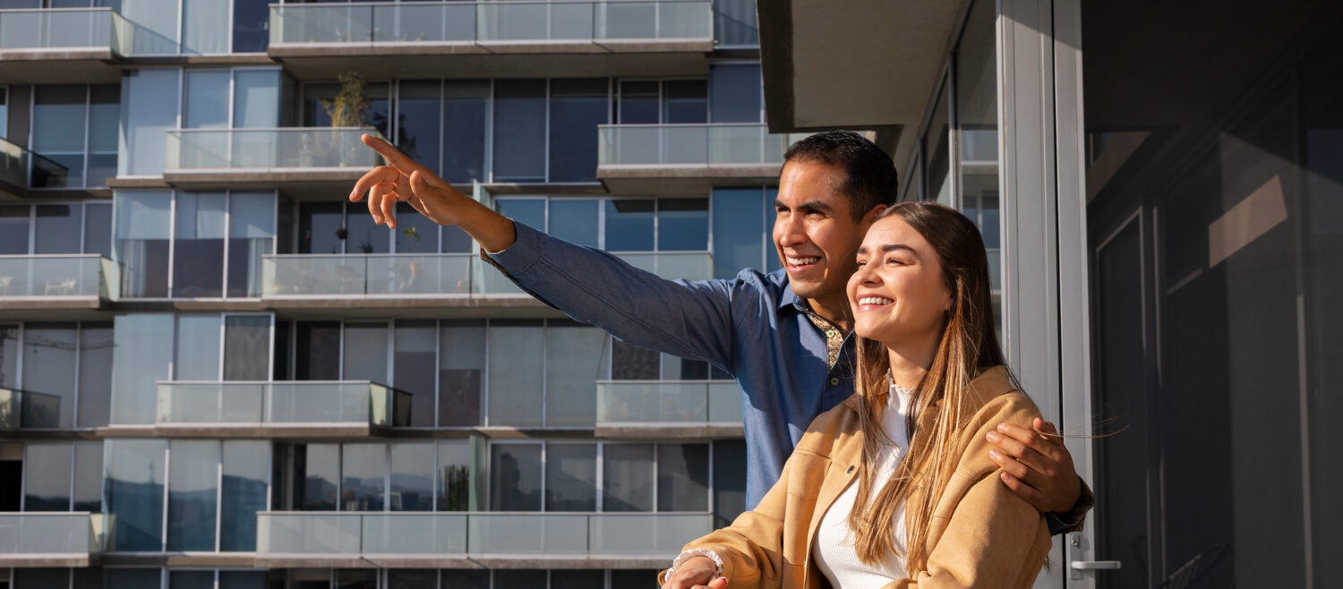 Casal em varanda de um apartamento moderno com fachada de vidro