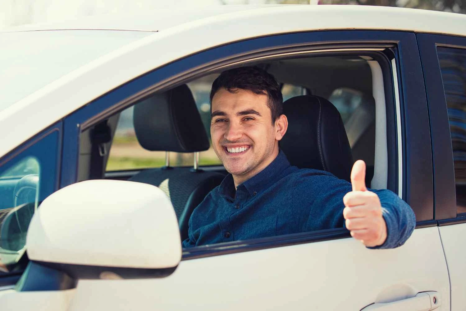 Homem sorridente dirigindo um carro e dando joinha para fora da janela, imagem relacionada a renda de uber e ifood para financiamento na caixa